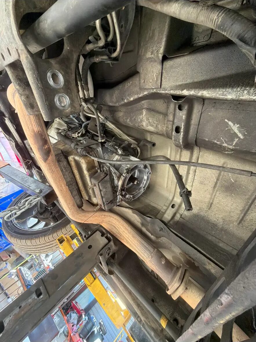 Transmission removed from underneath a vehicle on the lift